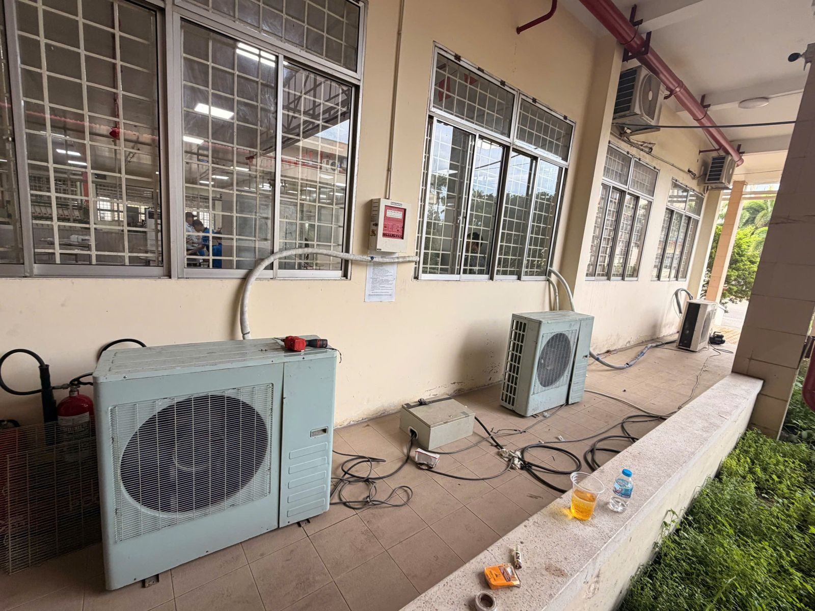 Giá Thuê Máy Lạnh Công Nghiệp: Các dàn nóng và đường ống tại hành lang cửa sổ trong giai đoạn lắp đặt.