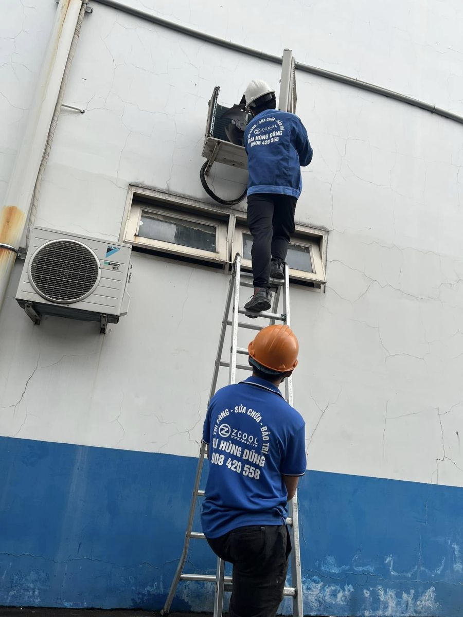Kỹ thuật viên dùng thang Sửa Máy Lạnh Công Nghiệp dàn nóng Daikin tại KCN VSIP
