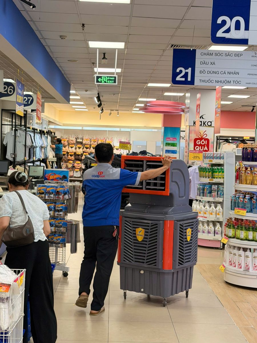 Nhân viên đẩy quạt công nghiệp có bánh xe trong siêu thị, cho thuê quạt công nghiệp giá rẻ