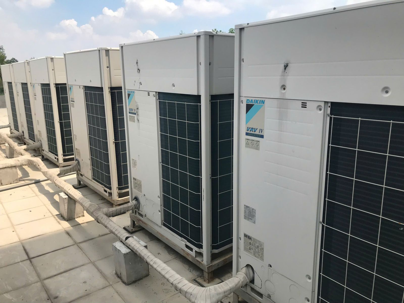 Thanh Lý Hệ Thống Máy Lạnh Công Nghiệp: Góc rộng các tủ Daikin VRV IV và đường ống đặt trên gối đỡ.