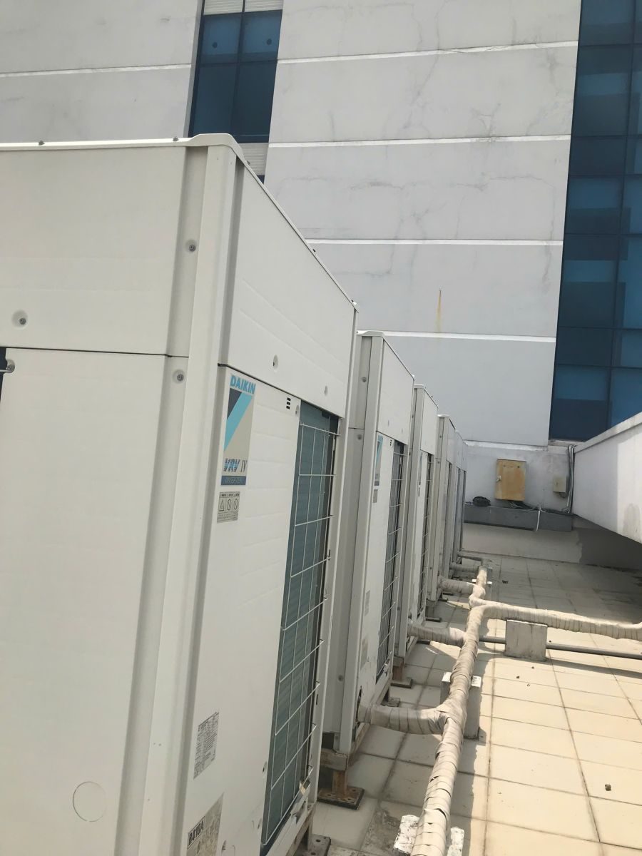 Thanh Lý Hệ Thống Máy Lạnh Công Nghiệp: Dãy dàn nóng Daikin VRV IV cạnh công trình với tuyến ống bọc bảo ôn phía dưới.